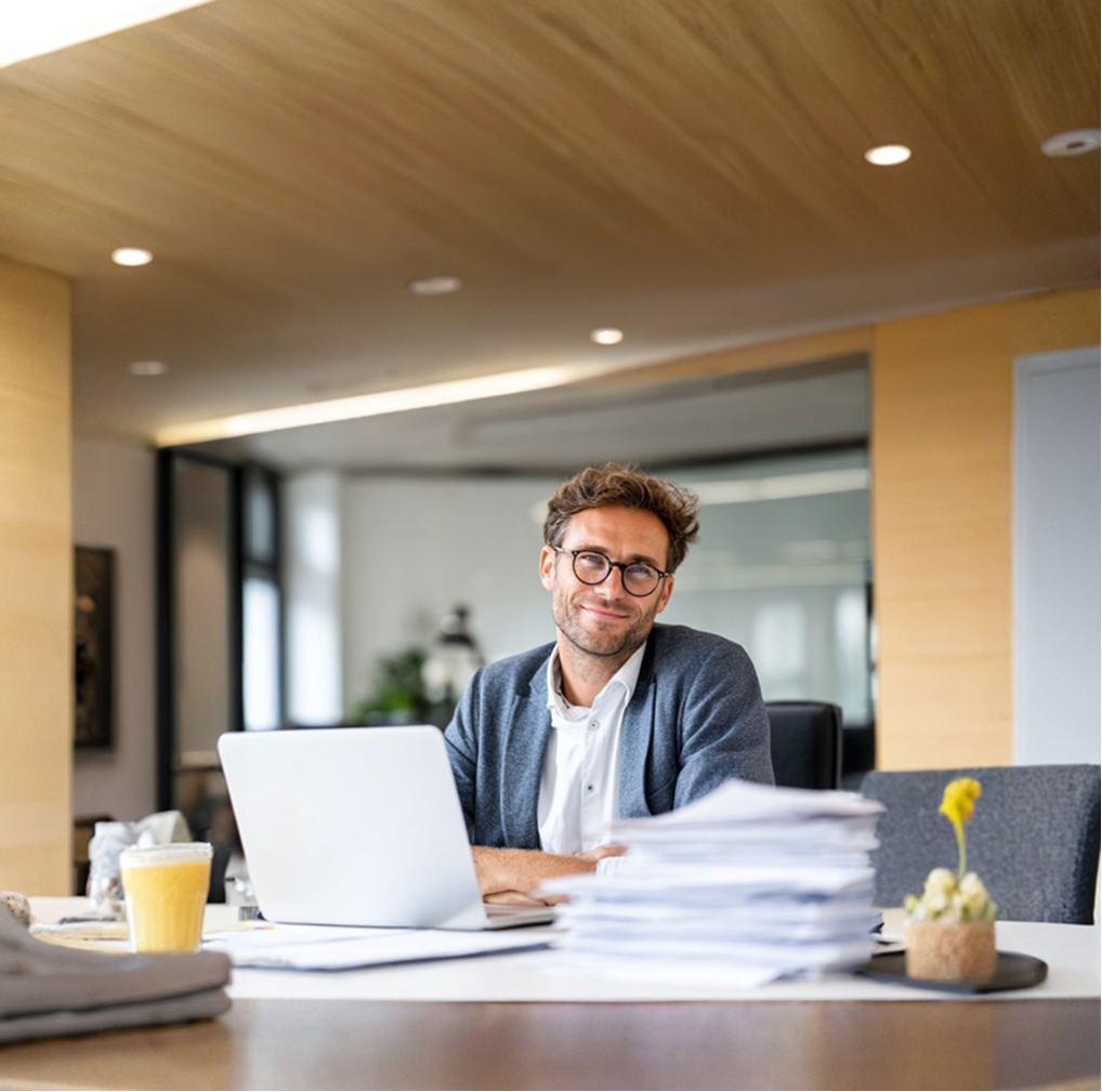 Steuerberater am Schreibtisch vor Laptop – professionelle Webpräsenz für KMUs